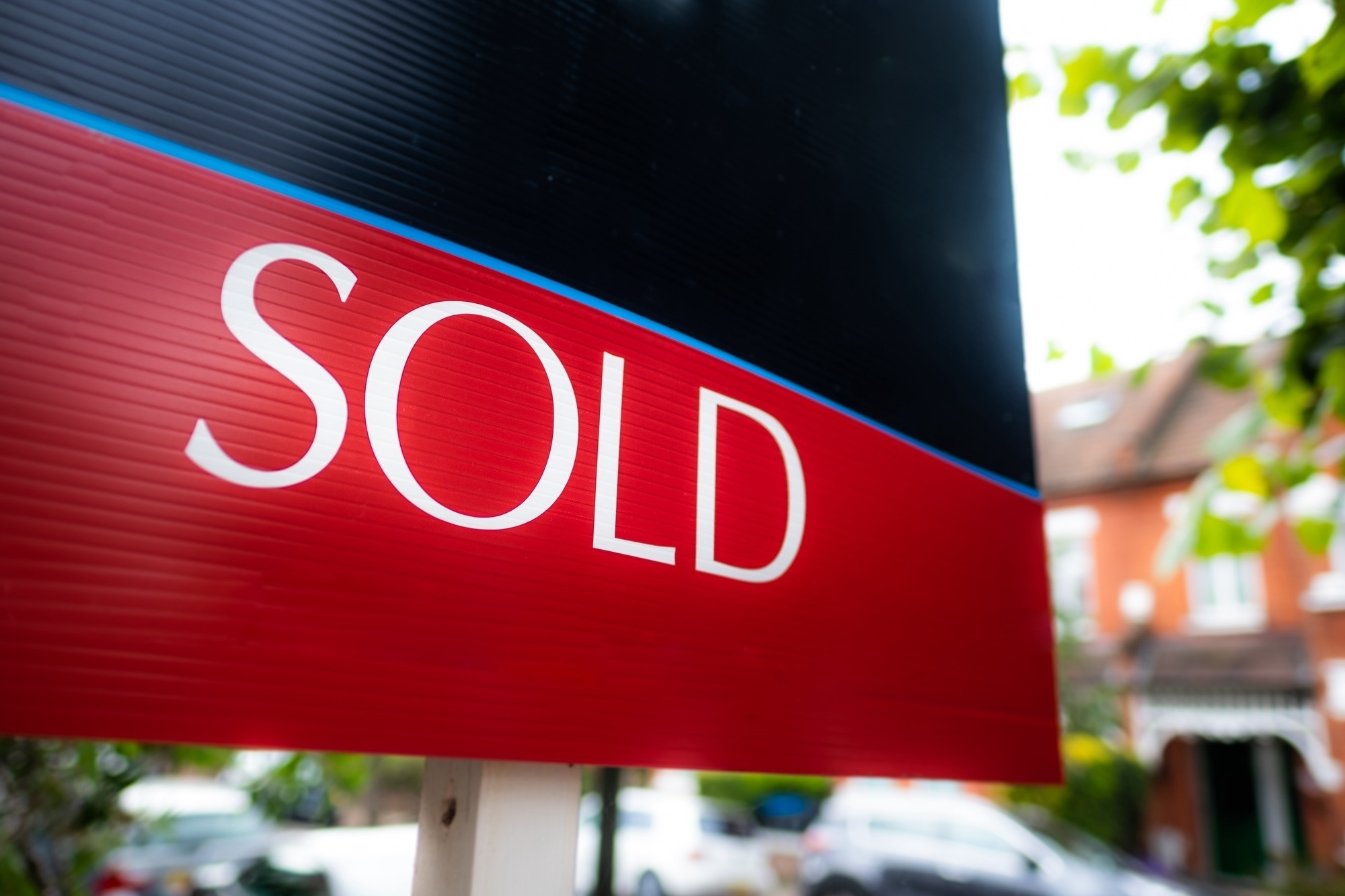 Ss estate agent sold sign on residential street