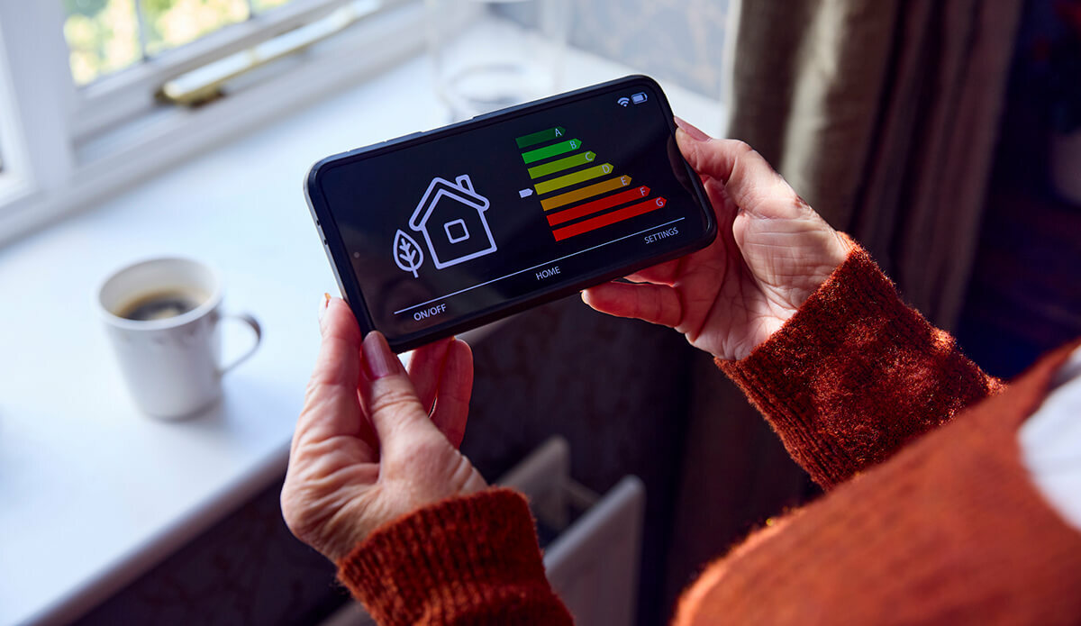 Woman holding heating monitor - data driven insights into household energy