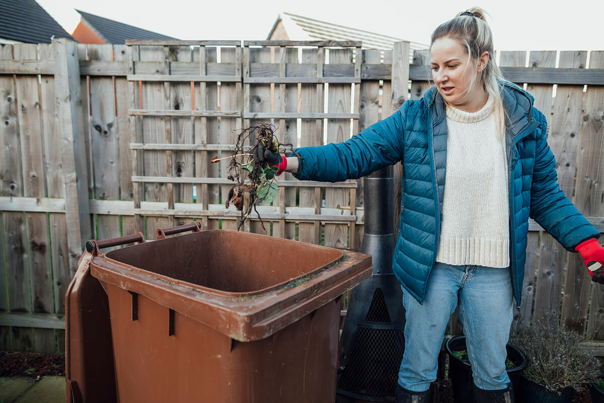 Woman using garden waste bin